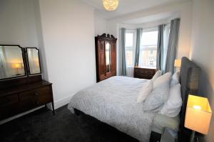 泰恩河畔纽卡斯尔Newcastle - Heaton - Great Customer Feedback - 5 Large Bedrooms - Period Property - Refurbished Throughout的一间卧室配有一张床、梳妆台和镜子