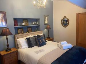 水上伯顿Broadlands的一间卧室配有带枕头和镜子的床