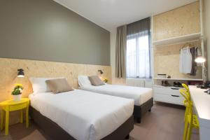 米兰B&B Hotel Milano Ornato的酒店客房配有两张床和一张书桌
