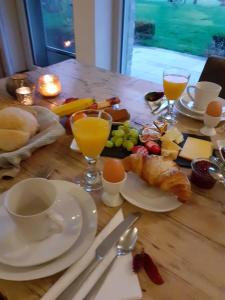波佩林赫De Zevende Zon的一张木桌,上面摆放着早餐食品和饮料
