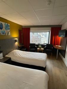 蒂尔堡蒂尔堡城市酒店的酒店客房设有两张床和窗户。