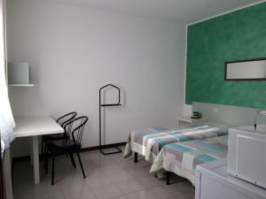 VerunoLa Locanda Di Perico Paola的客房设有两张床、一张桌子和一张书桌。