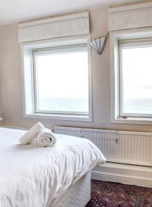 科肯希Fisherman's Cottage的卧室设有2扇窗户和1张白色床。