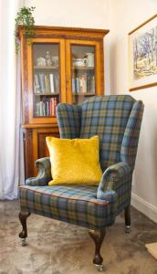科肯希Fisherman's Cottage的客厅里一张带黄色枕头的椅子