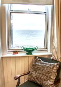 科肯希Fisherman's Cottage的坐在窗户上的带椅子的绿色碗