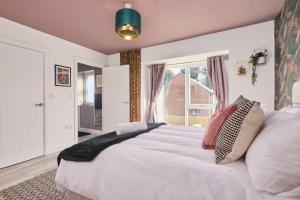 利兹Homebird Property - Ash Tree House的卧室设有一张白色大床和一扇窗户。