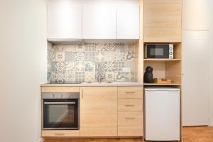 布拉加Sé Apartamentos - Casa Do Raio Center Apartments的厨房配有冰箱和微波炉。