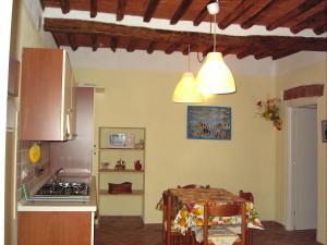 里奥马里纳Appartamenti Piombino Isola d'Elba的一间带桌子的厨房和一间带两个灯的厨房