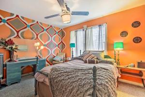 独立城Artsy Getaway about 8 Miles to Downtown Kansas City!的一间卧室设有橙色的墙壁、一张床和一张书桌