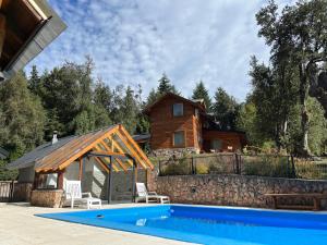 拉安戈斯图拉镇Portal del Manzano的房屋前有游泳池的房子