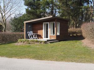 奥胡斯First Camp Aarhus - Jylland的小屋,配有椅子,位于草地上