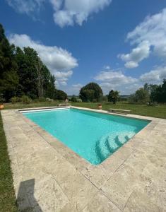 Saint-AntoineLA FERME DE VILLENEUVE的庭院里的一个蓝色海水游泳池