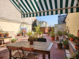 布宜诺斯艾利斯阿里巴大街住宿加早餐酒店的庭院配有木桌、椅子和盆栽植物