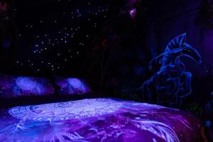 贝尔福Avataar - L'arbre de Pandoraa的一间暗室,配有一张紫色照明床