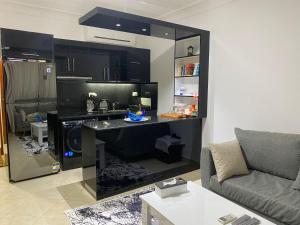 沙姆沙伊赫Renoviertes Luxusapartment Sunny Lakes 1 Sharm El-Sheikh nun auch für Langzeitmieter buchbar的客厅配有书桌和沙发。