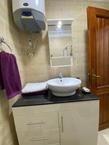 沙姆沙伊赫Renoviertes Luxusapartment Sunny Lakes 1 Sharm El-Sheikh nun auch für Langzeitmieter buchbar的一间带水槽和镜子的浴室