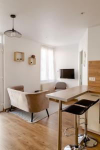 图尔Maison tourangelle chic & cosy avec cour的客厅配有木桌和椅子