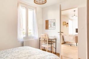 图尔Maison tourangelle chic & cosy avec cour的一间卧室配有一张床、一张书桌和一个窗户。