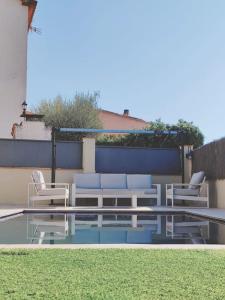 科尔百托Casa, parque natural de Montserrat cerca Barcelona的一个带桌椅的庭院和一个游泳池