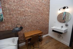 纽约The Flat NYC的一间卧室设有砖墙、桌子和水槽