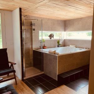 La JaudonnièreEcho d'Eau Host & Coach的带浴缸和玻璃淋浴间的浴室。