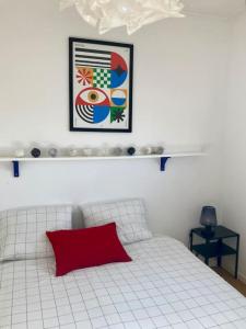 托农莱班Charmant Appartement Pop - Arty的卧室配有白色的床和红色枕头
