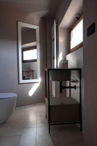 卡斯塔诺兰泽Alla Torre - nel cuore del Borgo storico的一间带水槽、卫生间和镜子的浴室