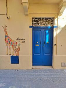 维多利亚Gawhra B&B的建筑物一侧带长颈鹿的蓝色门