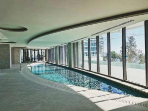 利马索尔Beachfront Boutique Residence的一座大型游泳池,位于一座带窗户的建筑内