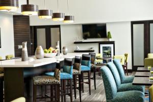 基奇纳希尔顿基奇纳汉普顿酒店及套房的一间设有蓝色椅子的餐厅和一间酒吧