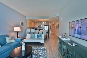 默特尔比奇Huge Ocean Front Condo, Amazing Views的客厅配有蓝色的沙发和电视