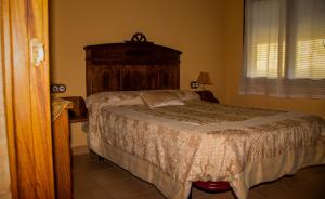 纳瓦孔塞霍CASA RURAL EL RONDILLO的一间卧室配有一张带木制床头板的床