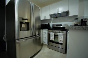 圣地亚哥洛斯卡巴The apartment you dreamed of 2 !的厨房配有不锈钢冰箱和炉灶。