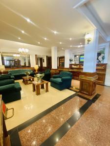 科尔多瓦HOTEL CASTELAR CORDOBA的一个带绿色沙发和桌子的大客厅