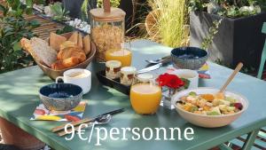 博凯尔Le petit coin de Provence的餐桌,早餐包括面包和橙汁
