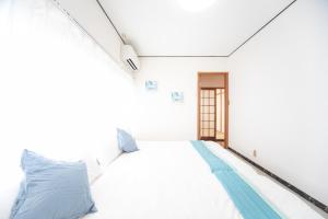 四日市Yokkaichi - House - Vacation STAY 68949v的一间卧室配有白色床和蓝色枕头