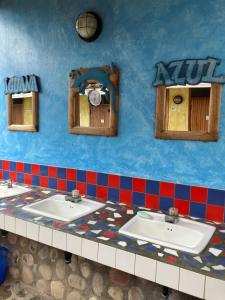 科潘玛雅遗址Hostel Iguana Azul的一间带三个水槽和蓝色墙壁的浴室