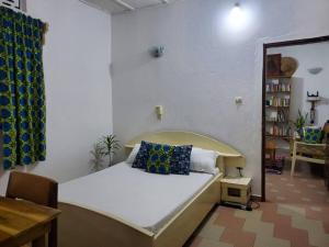 OuidahMaison fleurie Ouidah的一间卧室配有一张带枕头的床