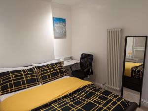 伦敦Fully-equipped flat in the city of London.的一间卧室配有一张床、一把椅子和镜子