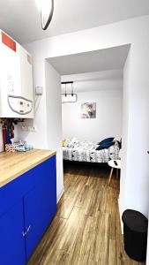 锡比乌Grand Central Studios的一间带蓝色橱柜的厨房和一间带一张床的卧室