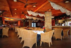 圣蓬萨海盗村酒店的用餐室配有桌子和藤椅