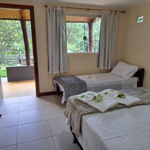 戈亚斯州上帕莱索Casa Nirvana para Temporadas的酒店客房设有两张床和窗户。