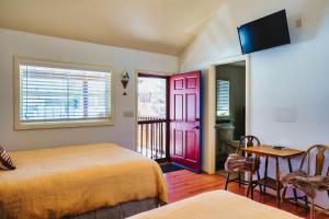 埃斯卡兰特The Loubird Inn的一间卧室设有两张床和红色的门