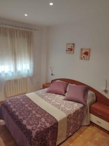 瓦德诺比斯Apartamento Torre Sancho的一间卧室配有一张带紫色枕头的大床