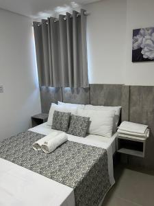 伊波茹卡Apartamento com piscina no Condominio Maraca2的卧室配有一张带白色床单和枕头的大床。