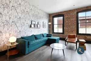 新奥尔良Roami at The Brandywine的客厅设有蓝色的沙发和砖墙