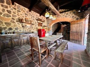 危地马拉安地瓜Villas Gasconia的厨房配有木桌和石墙