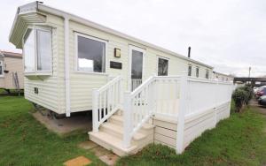 Belton3 bed caravan Norfolk near the coast的白色移动房屋 - 带白色楼梯