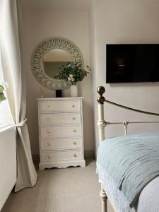 伊尔克利Wellington Cottage的卧室配有白色梳妆台和镜子