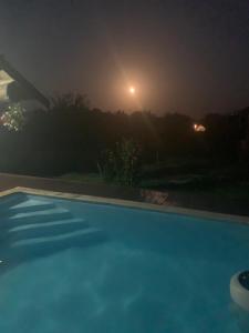 Popas Regal的夜间游泳池,月亮为背景